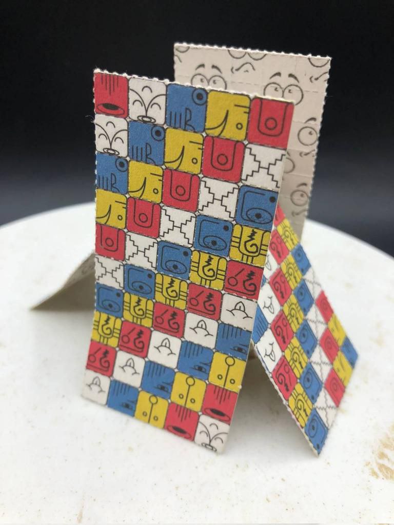 E269AD1F-5010-43C0-BA45-E0C816B5C827 Close-up of colorful LSD blotter paper tabs with printed artwork on perforated squares