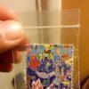 Colorful rainbow-printed LSD blotter paper sheet with cartoon character perforated artwork
