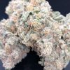 White Widow hybrid cannabis buds with chunky conical shape, spring green leaves, and dense frosty trichome coating