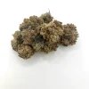 Black Mamba indica cannabis flower showing dense dark green and purple nugs coated in frosty white trichomes