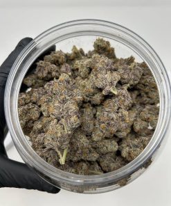 Top-down view of Strawberry Cough strain nugs showing sticky resinous coating and vibrant green and red coloring