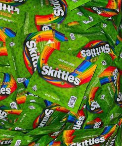 Close-up of individual THC Skittles candy pieces showing vibrant sour fruit colors