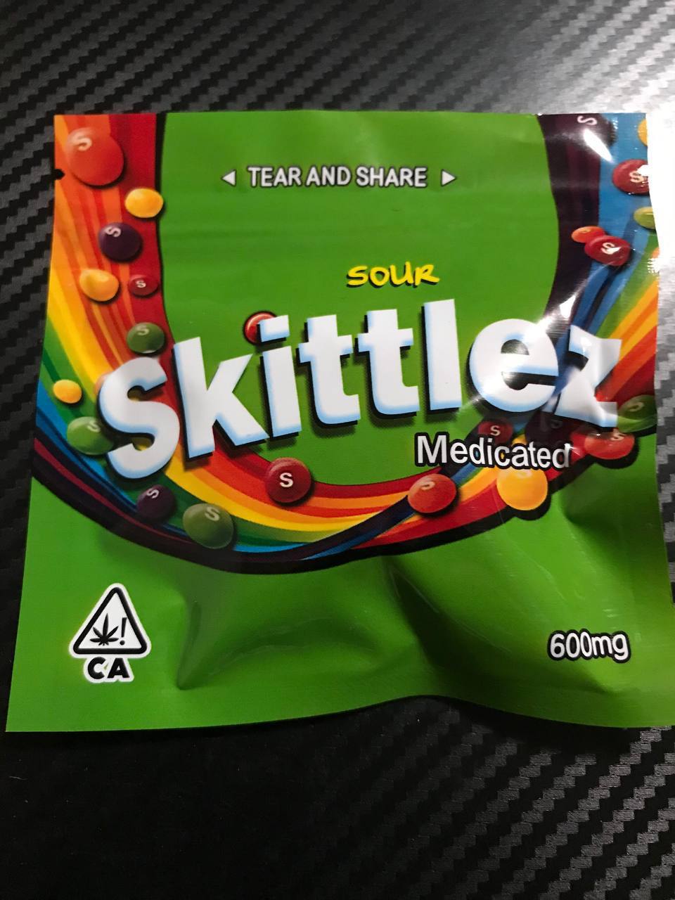 Medicated Skittles – 20 Pieces Per Pack Colorful Skittles candy pouch with rainbow candies spilling out.