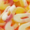 Vibrant peach ring-shaped edibles with natural fruit flavor, individually wrapped in a fun candy design.