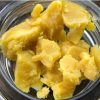 Golden-green Tahoe OG Wax concentrate in glass jar