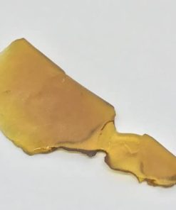 Glowing golden Hawaiian Shatter cannabis concentrate in jar, ultra-pure THC extract