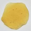 Golden Khalifa Kush Shatter with rich amber hue, potent THC extract, sticky texture, premium cannabis concentrate.