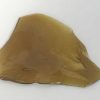 Golden OG Kush Shatter with rich amber color and glass-like texture on parchment paper