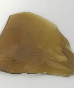 Golden OG Kush Shatter with rich amber color and glass-like texture on parchment paper